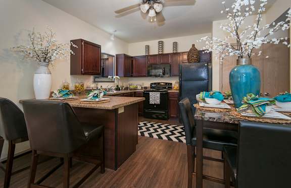 A kitchen with a table and chairs.