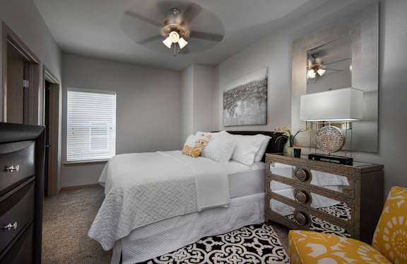 A bedroom with a bed, dresser, and mirror.