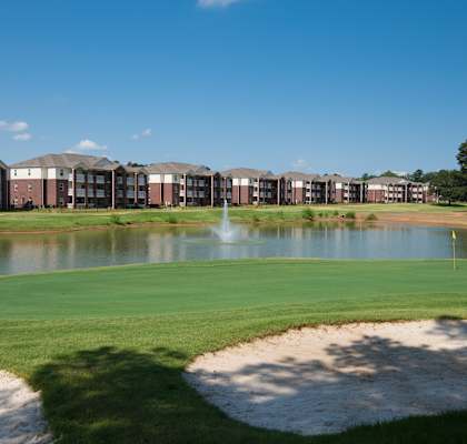 A golf course with a pond and sand traps.