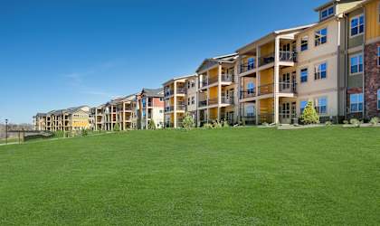 Apartment complex with green grass in front.