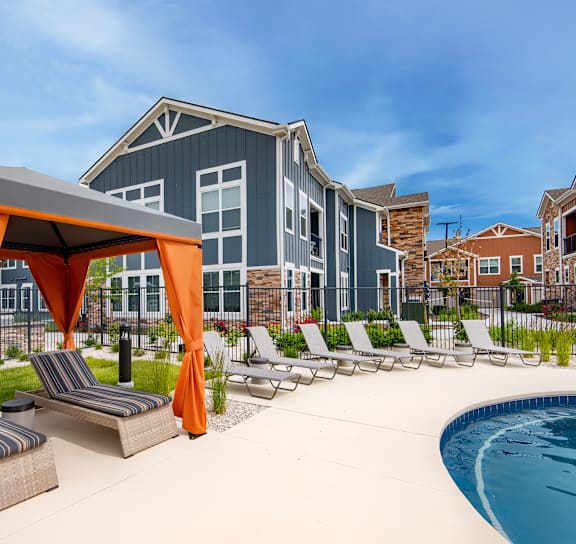 A pool area with a canopy and lounge chairs at Watermark on Twenty Mile, Parker, 80134