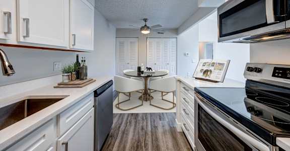 A modern kitchen with white cabinets and a wooden island.