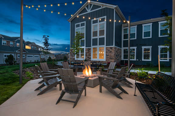 A fire pit is surrounded by chairs on a patio at Watermark on Twenty Mile, Parker, 80134