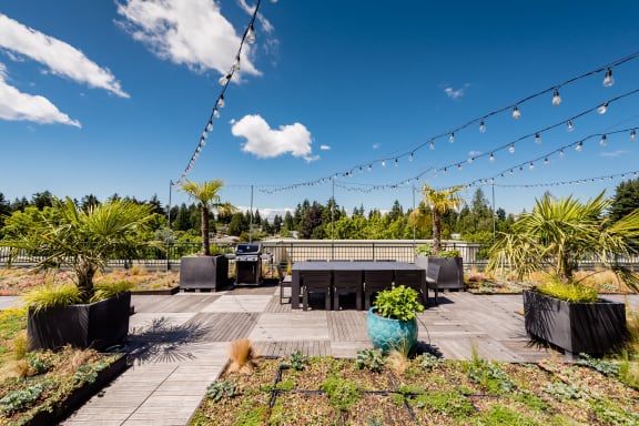 a patio with a table and chairs under a blue sky