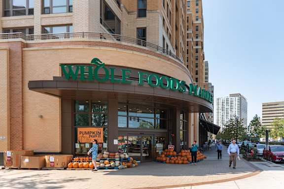 A Whole Foods store with pumpkins displayed outside.