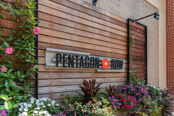 A Pentagon Row sign is displayed on a wooden wall.
