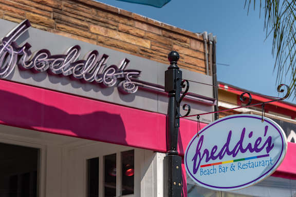 A sign for Breddie's Beach Bar & Restaurant is displayed on a building.