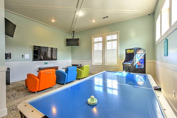 a game room with a ping pong table and a video game