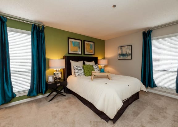 a bedroom with green walls and a white bed