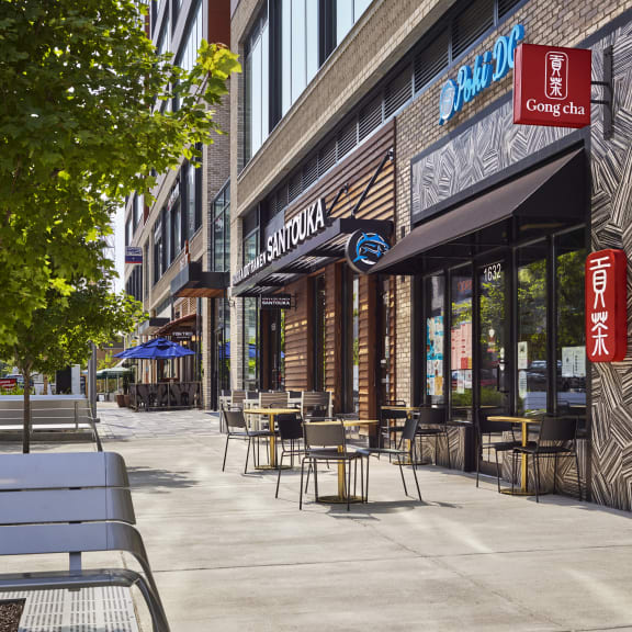 a sidewalk cafe with tables and chairs outside of a brick building