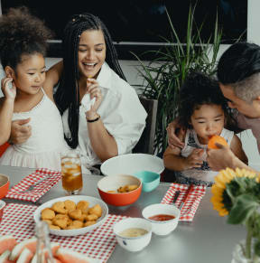 a family sitting at a table eating food together