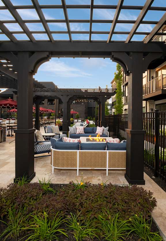 A patio with a table and chairs under a pergola.