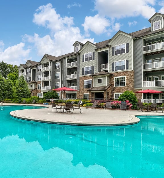 a swimming pool with an apartment building in the background
