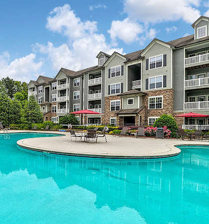 a swimming pool with an apartment building in the background