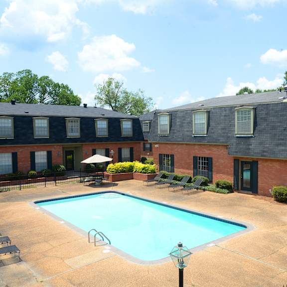 A swimming pool surrounded by a fence and chairs.