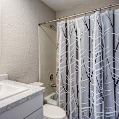 a bathroom with a shower and a sink and a toilet