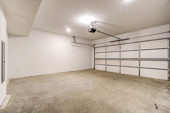 A spacious garage with a white wall and a white door.