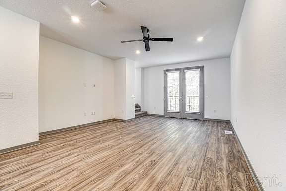 A room with a ceiling fan and a sliding glass door.