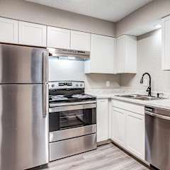 a kitchen with white cabinets and stainless steel appliances