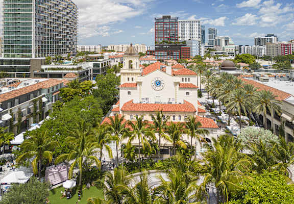 a church with palm trees in front of a city skyline