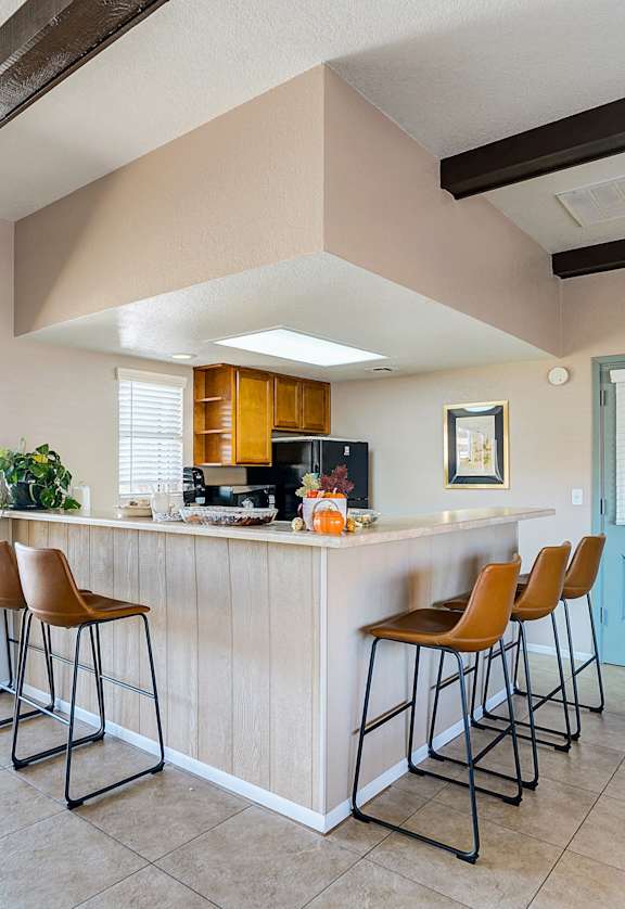 a kitchen with a bar and chairs in front of a door