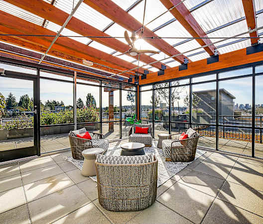 a patio with wicker furniture and a glass roof at The Hayes on Stone Way, Seattle, WA, 98103