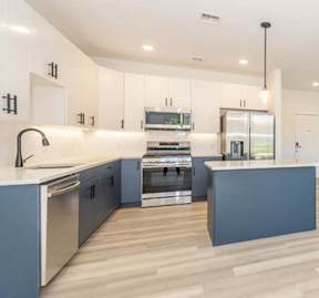 A modern kitchen with a large island and stainless steel appliances.