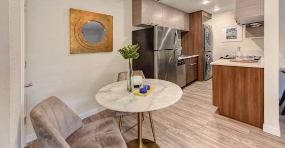Dining Room with View of Kitchen, Ceiling Fan, White Round Table, Refrigerator and Mirror on Wall