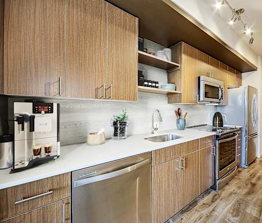 a kitchen with wooden cabinets and stainless steel appliances at The Hayes on Stone Way, Seattle, WA, 98103