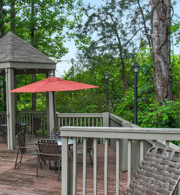 a gazebo with a table and chairs on a deck