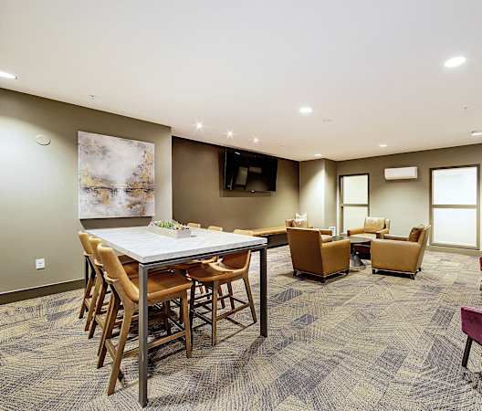 a living room with a table and chairs and a television at The Hayes on Stone Way, Seattle, WA, 98103