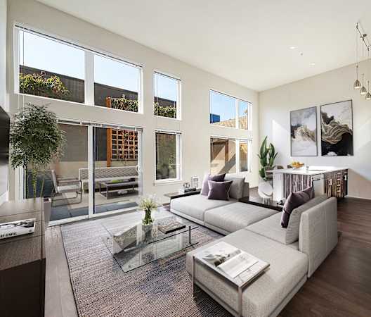 a living room with a couch and a coffee table and large windows at The Hayes on Stone Way, Seattle, WA, 98103