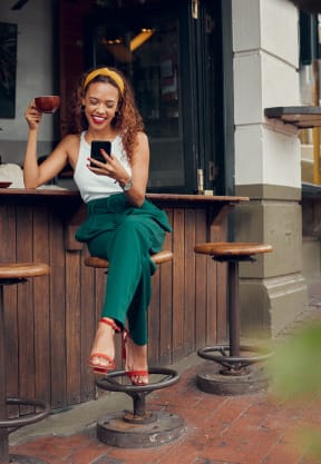 a woman sitting on a bench looking at her cell phone