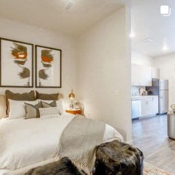a bedroom with a bed and a kitchen