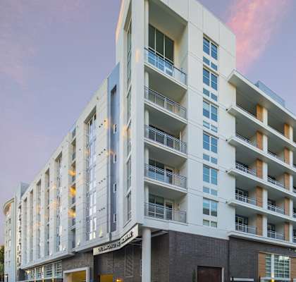 A modern apartment building with balconies and multiple floors.