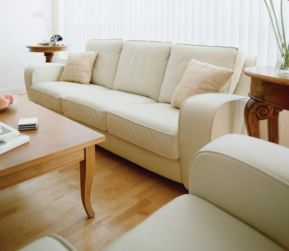 A white couch with a wooden coffee table in front of it at Pleasantview Apartments, Maryland 21214