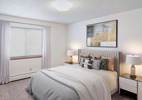 A bedroom with a large bed, a potted plant, and a window with curtains.