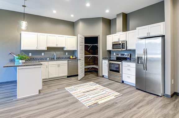 A modern kitchen with stainless steel appliances and white cabinets.