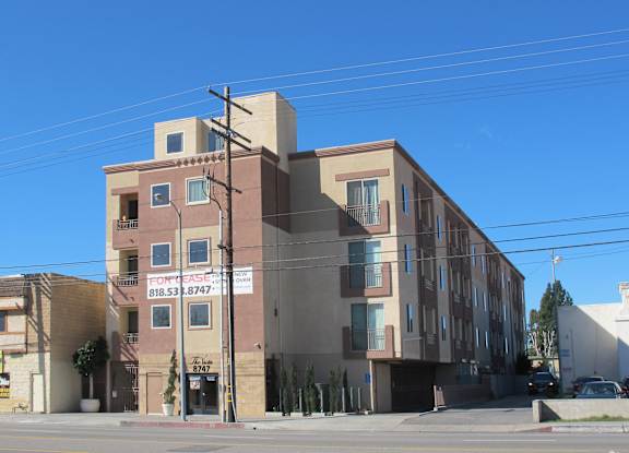 A building with a sign that reads "818.53.8747" is shown.