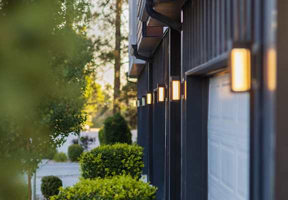 A row of lights are on the side of a building.