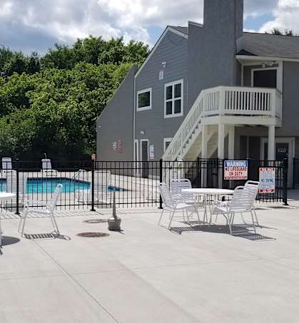 the pool area of a house with a swimming pool and patio chairs
