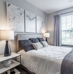 a bedroom with a large bed and a window at The Louis Apartment Flats, Louisville, KY