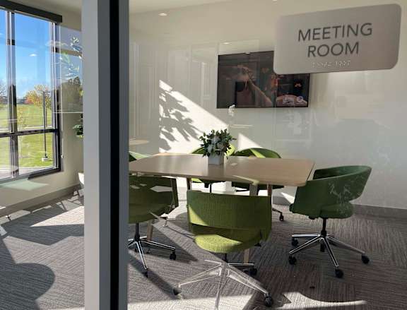 a meeting room with a table and chairs and a meeting room sign at 42 Hundred On The Lake, St Francis, 53235