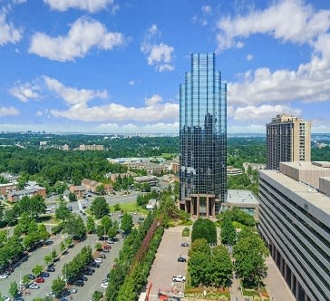an aerial view of a city with a tall skyscraper