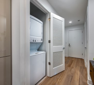 a walk in closet with two wire racks and a white robe and a red jacket