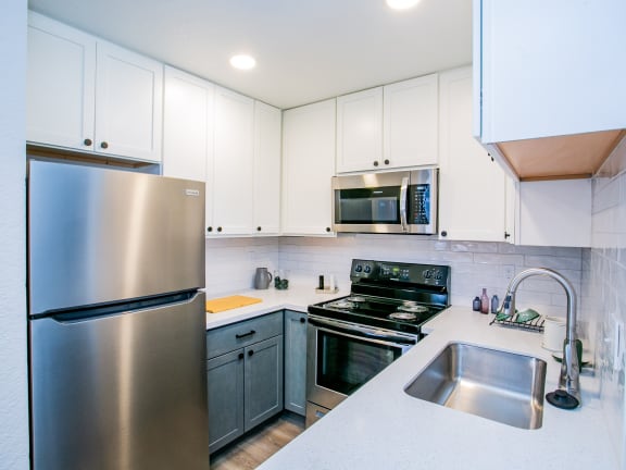 a kitchen with stainless steel appliances and white cabinets