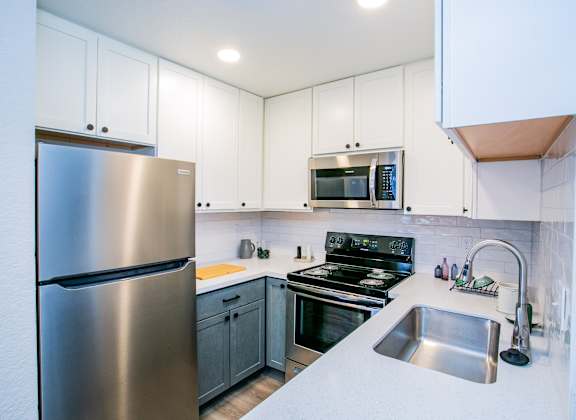 a kitchen with stainless steel appliances and white cabinets