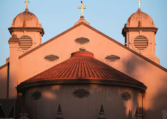 A church with three towers and a cross on top is shown.