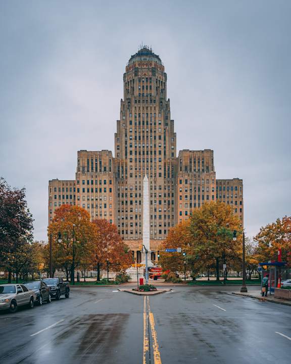 A large, historic building dominates the cityscape in the image at 100 South Apartments, Buffalo, New york