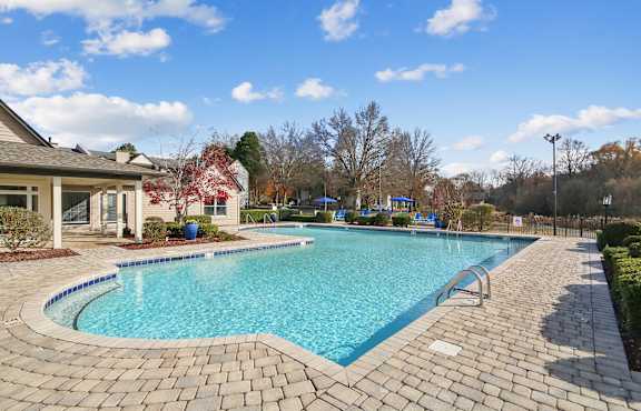 A swimming pool surrounded by a brick patio.
